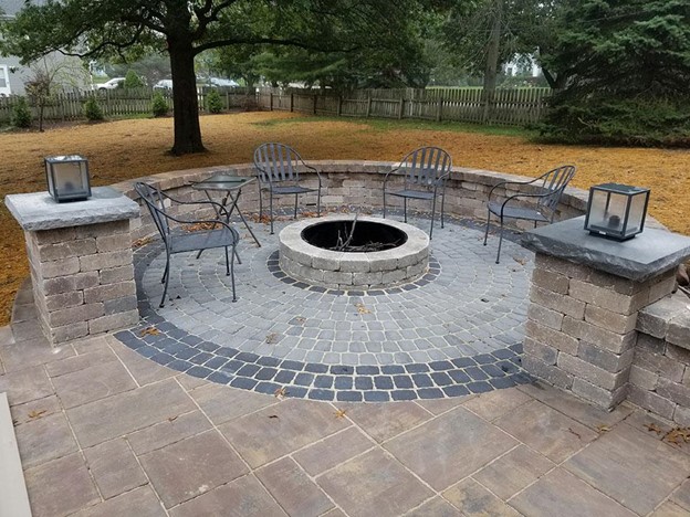 Patio with circular fire pit and chairs.